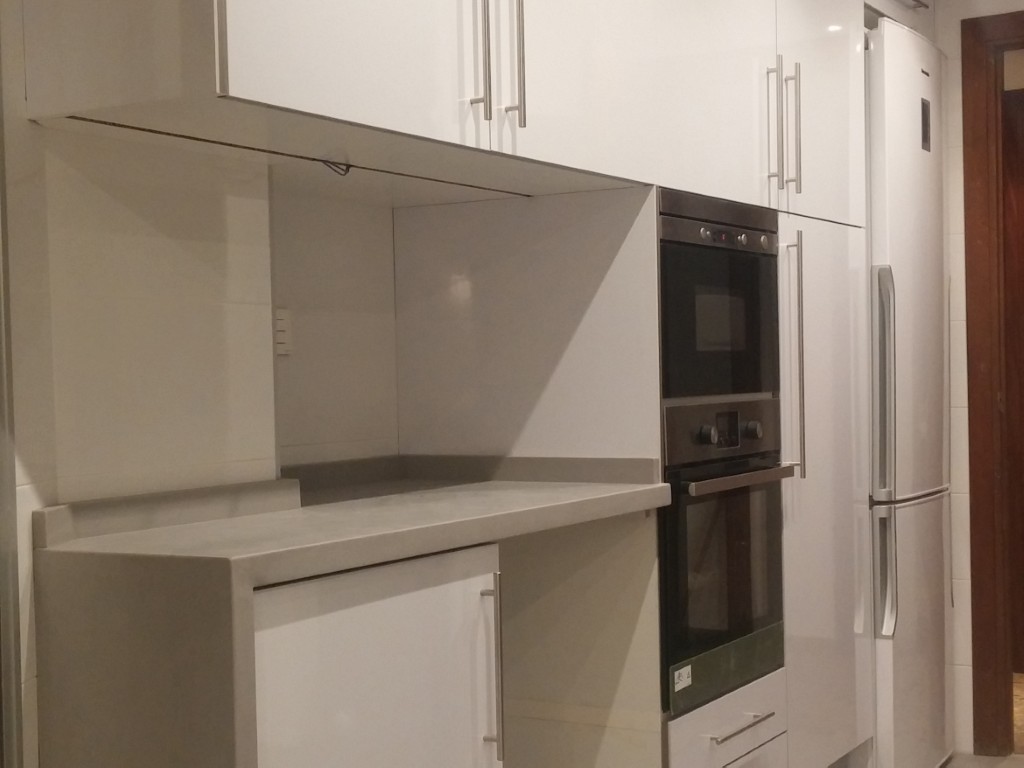 Cocina reformada en Valencia con mobiliario blanco y electrodomésticos integrados