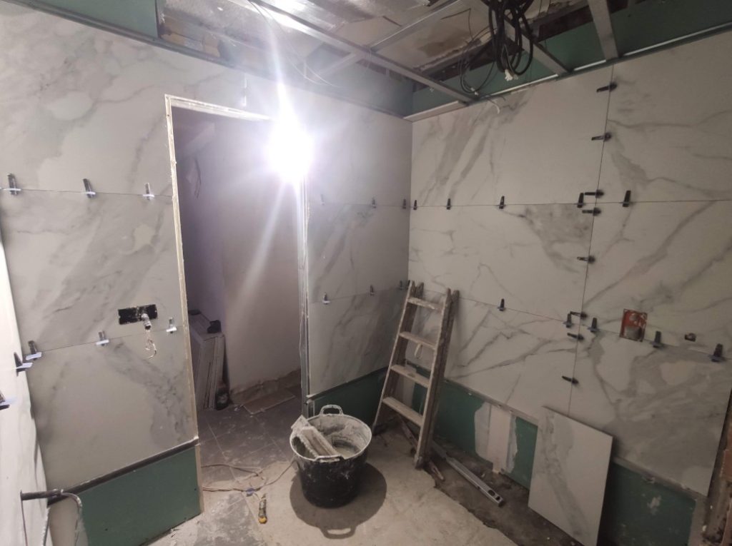 Colocación de grandes piezas porcelánicas efecto mármol en un baño