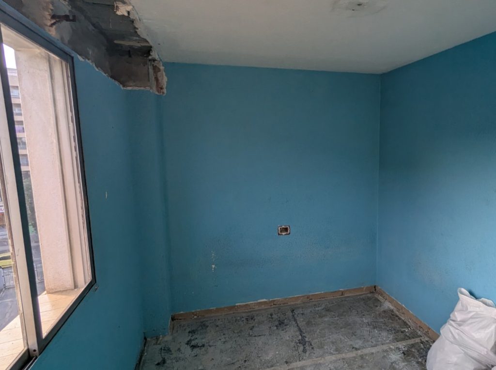 Estancia durante una reforma integral con paredes y pavimento en proceso de demolición
