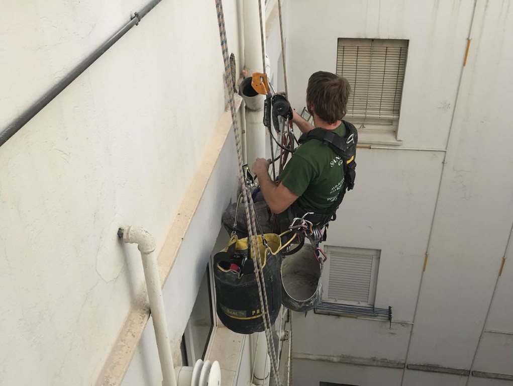 Trabajador realizando trabajos verticales en fachada mediante acceso por cuerda