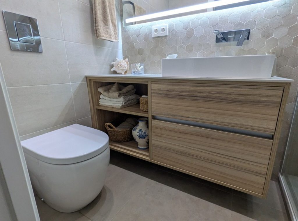 Baño reformado en Valencia con lavabo sobre encimera y revestimiento hexagonal