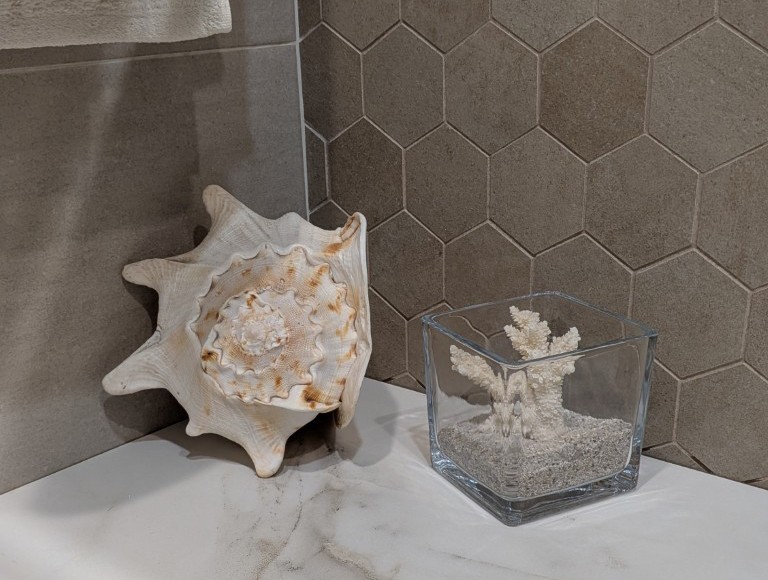 Detalle decorativo en baño reformado con revestimiento hexagonal en Valencia