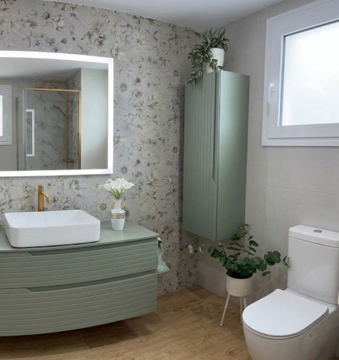 Baño reformado con mueble verde y revestimiento decorativo